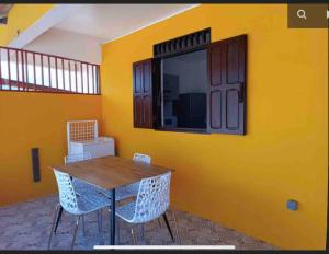 a dining room with a yellow wall with a table and chairs at Mana - SRFB 3 in Mana