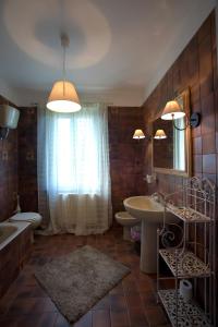 La salle de bains est pourvue d'un lavabo, d'une baignoire et de toilettes. dans l'établissement Posto Nove Country House, à Corropoli