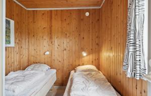 a bedroom with wooden walls and two beds in it at Beautiful Home In Odder With Wifi in Norsminde