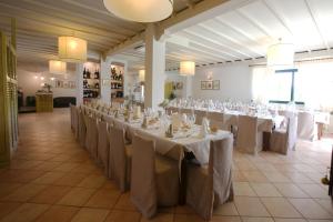 a large banquet hall with white tables and chairs at Posto Nove Country House in Corropoli