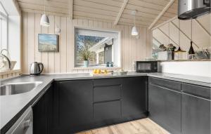 a kitchen with black cabinets and a sink at Three-Bedroom Holiday Home In Knebel in Knebel