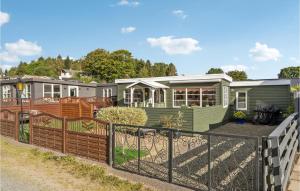 una casa verde con una valla delante en Stunning Home In Bjert With House Sea View, en Binderup Strand