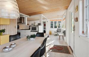 cocina y comedor con mesa de madera grande y sillas en Stunning Home In Bjert With House Sea View, en Binderup Strand
