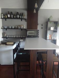 una cocina con una mesa blanca y algunas sillas en ROCAYAS HOME en Esquel