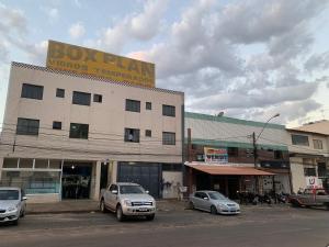 a building with cars parked in a parking lot at apartamento ADE 101, wifi in Brasilia