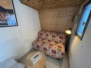 Cette petite chambre comprend un lit et une chaise. dans l'établissement Studio Les Angles, 1 pièce, 2 personnes - FR-1-593-95, aux Angles