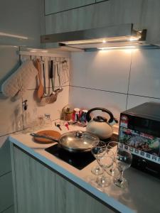 a kitchen with a stove top with wine glasses on it at Infinity pool apartment with stunning sunset view - GM Remia Residence Ambang Botanic in Klang