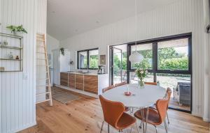 ヒュールスミンネにあるAwesome Home In Juelsminde With 3 Bedrooms And Wifiのキッチン、ダイニングルーム(白いテーブル、椅子付)