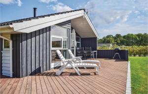 una terraza con 2 sillas y una casa en Stunning Home In Juelsminde With 3 Bedrooms, Sauna And Wifi, en Sønderby
