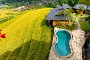 an aerial view of a house with a swimming pool in a field at Black Ship Sapa in Sa Pa