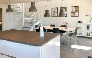 una cocina con mesa y sillas y una escalera en Cozy Home In Rm With Wifi en Sønderby