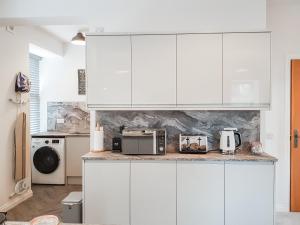 uma cozinha branca com electrodomésticos num balcão em Invergyle - Uk40566 em Ilhas Malvinas
