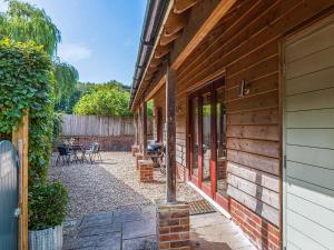 a side view of a house with a patio at The Cow Shed in Farnham