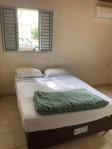 1 cama en un dormitorio con ventana en Casa centrica!, en Artigas