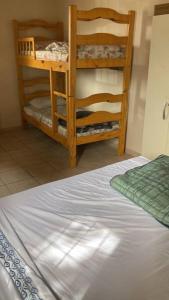 a bedroom with a bed and two wooden bunk beds at Casa centrica! in Artigas