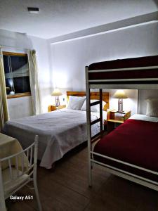 a bedroom with two bunk beds and a window at Wayra Hospedaje in Cajamarca