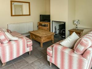 a living room with two couches and a coffee table at The Coach House - Hw7593 in Bettws-yn-Rhôs