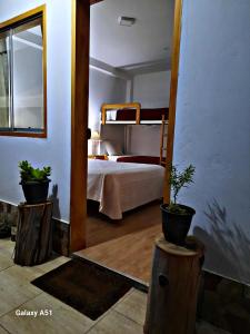 a bedroom with a bed and two potted plants at Wayra Hospedaje in Cajamarca