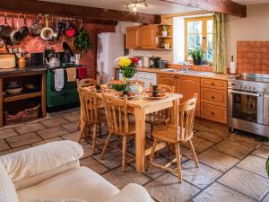 a kitchen with a wooden table and chairs at Hen Efail - Old Smithy in Tregaron