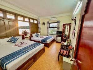a hotel room with two beds and a window at Phoenix Flower Hotel in Cat Ba +73 photos