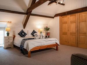 a bedroom with a bed with two stuffed animals on it at Hen Efail - Old Smithy in Tregaron