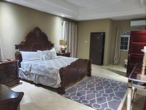 Un dormitorio con una cama grande y una alfombra azul en The Palms- Caribbean Estates -10 minutes from the beach- Gated Community, en Portmore