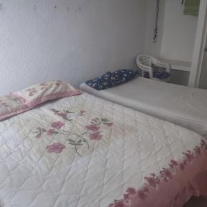 a bed with a white bedspread with flowers on it at Casa de descanso in Acapulco