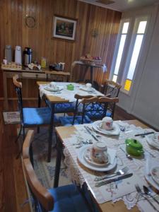 un comedor con una mesa con platos. en Pousada Vivenda das Flores Ltda, en Bom Jardim da Serra