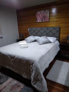 a bedroom with a large bed with white sheets and pillows at Pousada Vivenda das Flores Ltda in Bom Jardim da Serra