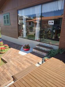 un patio trasero con una terraza de madera y una casa en Pousada Vivenda das Flores Ltda, en Bom Jardim da Serra