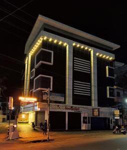 un edificio con luces por la noche en SREENARAYANA TOURIST HOME, en Guruvāyūr