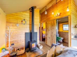a living room with wood paneling and a wood stove at The Owls Hollow - Uk45297 in Bishop Thornton
