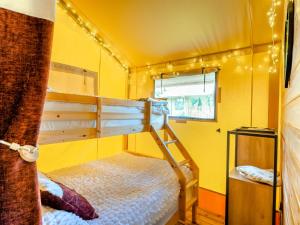 a bedroom with two bunk beds in a yellow room at The Owls Hollow - Uk45297 in Bishop Thornton