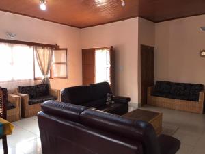 a living room with a leather couch and chairs at Villa Sophie à Sassara Pk 12 Bangui in Bangui
