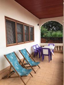a patio with chairs and a table and a table and chairs at Villa Sophie à Sassara Pk 12 Bangui in Bangui