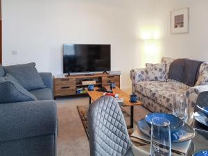uma sala de estar com sofás e uma televisão de ecrã plano em Liquorstane - Uk40568 em Falkland