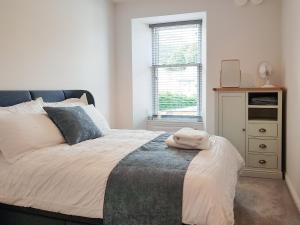 een slaapkamer met een bed, een dressoir en een raam bij Liquorstane - Uk40568 in Falkland