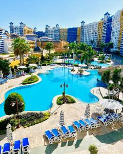 a resort with a pool and chairs and buildings at PORTO MARINA North Coast -الساحل الشمالي بورتو مارينا العلمين in El Alamein