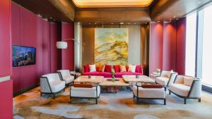 a living room with red walls and a couch and chairs at Diaoyutai Hotel Qingdao in Qingdao