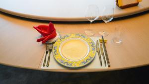 une assiette avec un chapeau rouge sur une table et des verres à vin dans l'établissement Diaoyutai Hotel Qingdao, à Qingdao