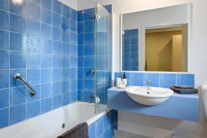 a blue tiled bathroom with a sink and a shower at Motel Strahan in Strahan