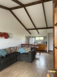 ein Wohnzimmer mit einem Sofa und einem Tisch in der Unterkunft Mata ki te Rangi Rapa Nui in Hanga Roa