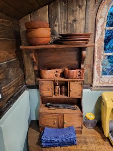 a wooden shelf with pots and pans on top of it at Hobbit Haven in Santa Barbara