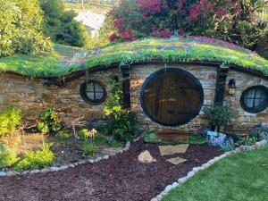 a small stone house with a door in a garden at Hobbit Haven in Santa Barbara