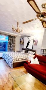een slaapkamer met een bed, een bank en een plafondventilator bij Fox Lodge in Drogheda