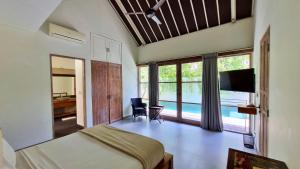 a bedroom with a bed and a desk and a television at The Decks Bali in Legian +42 photos