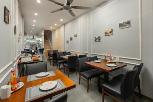 een restaurant met tafels en stoelen en een plafondventilator bij La Renta Premier Hotel & Spa Hanoi in Hanoi