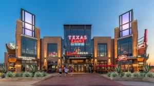 um grande edifício com pessoas andando na frente dele em Walk to AT&T Stadium , Globelife from Cozy 2bd/ba Apartment em Arlington