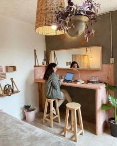 two women sitting at a kitchen counter with a laptop at Casa Boutique 55 in San Cristóbal de Las Casas +82 photos