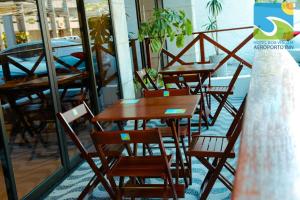 a row of wooden tables and chairs on a balcony at Hotel Boa Viagem Aeroporto in Recife +15 photos